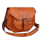 Tan crossbody bag with curved flap, front buckle pocket and adjustable strap, three-quarter view.