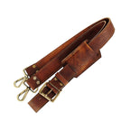 Brown adjustable shoulder strap folded to show its padded section, buckle and metal hooks.