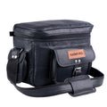 Black camera bag with a zippered top, front buckle pocket and shoulder strap, three-quarter view.