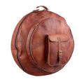 Brown round cymbal case with top handle and a front buckle pocket, three-quarter view.