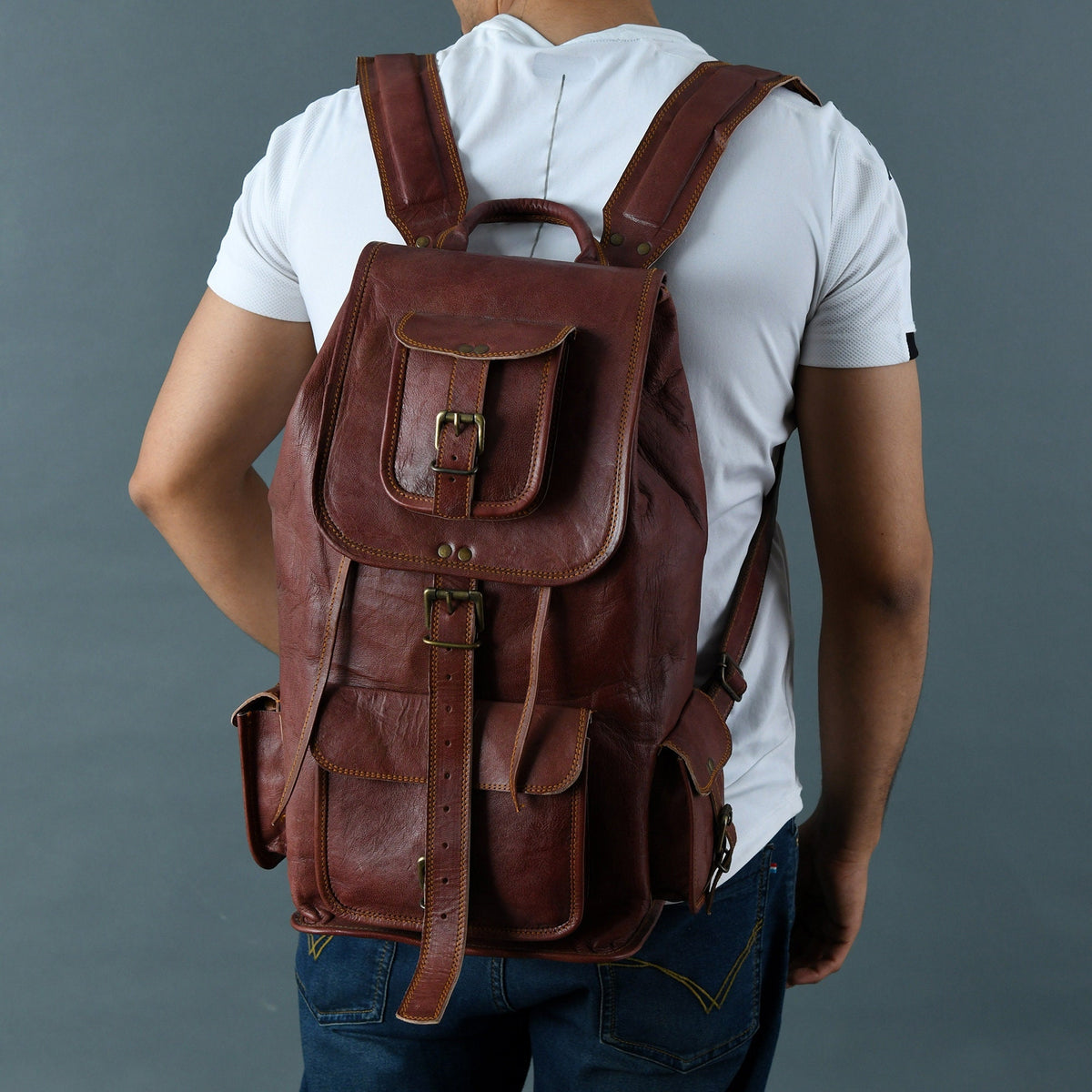 Brown leather backpack worn with a light shirt